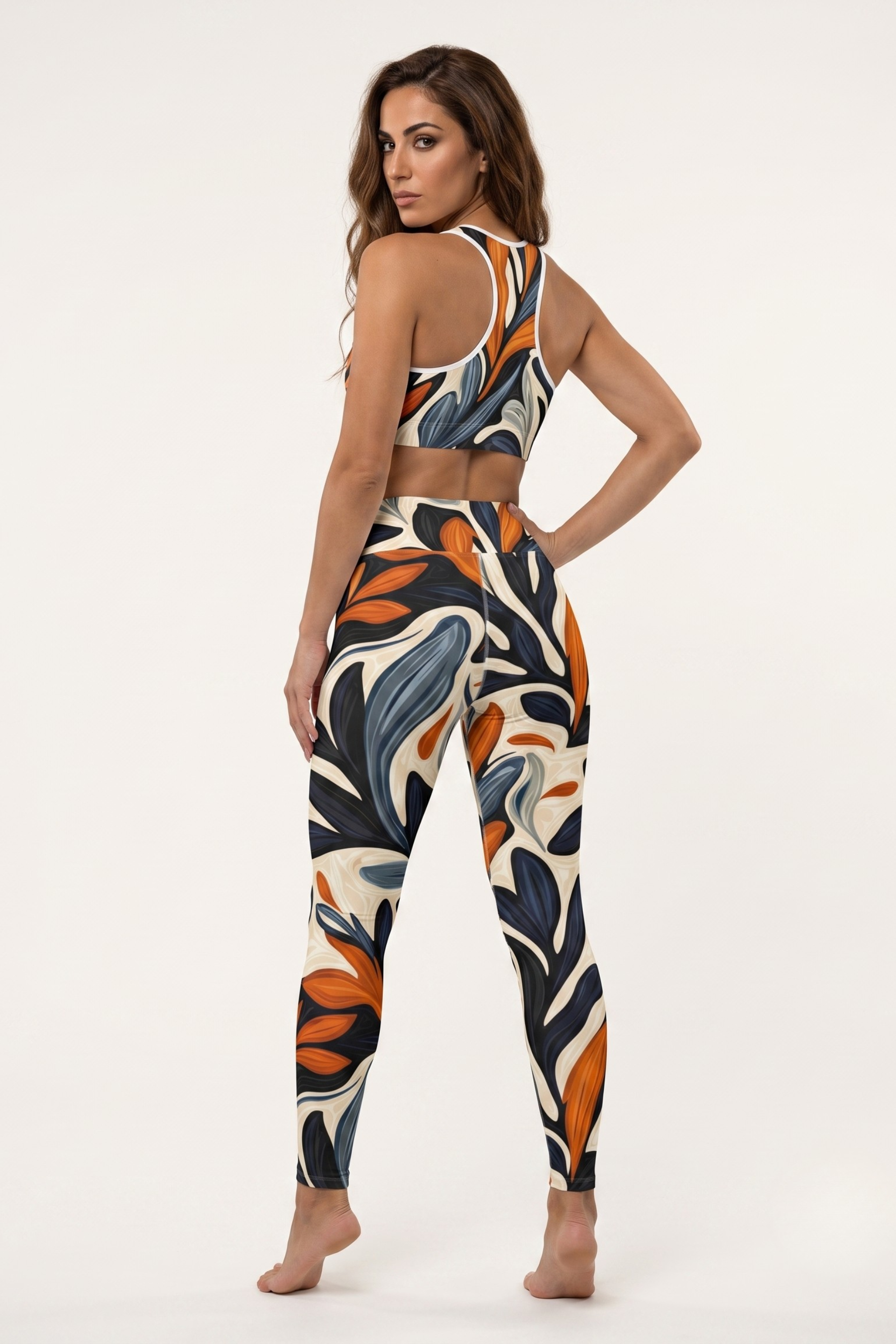 Woman wearing a colorful floral sports bra and leggings set on a white background