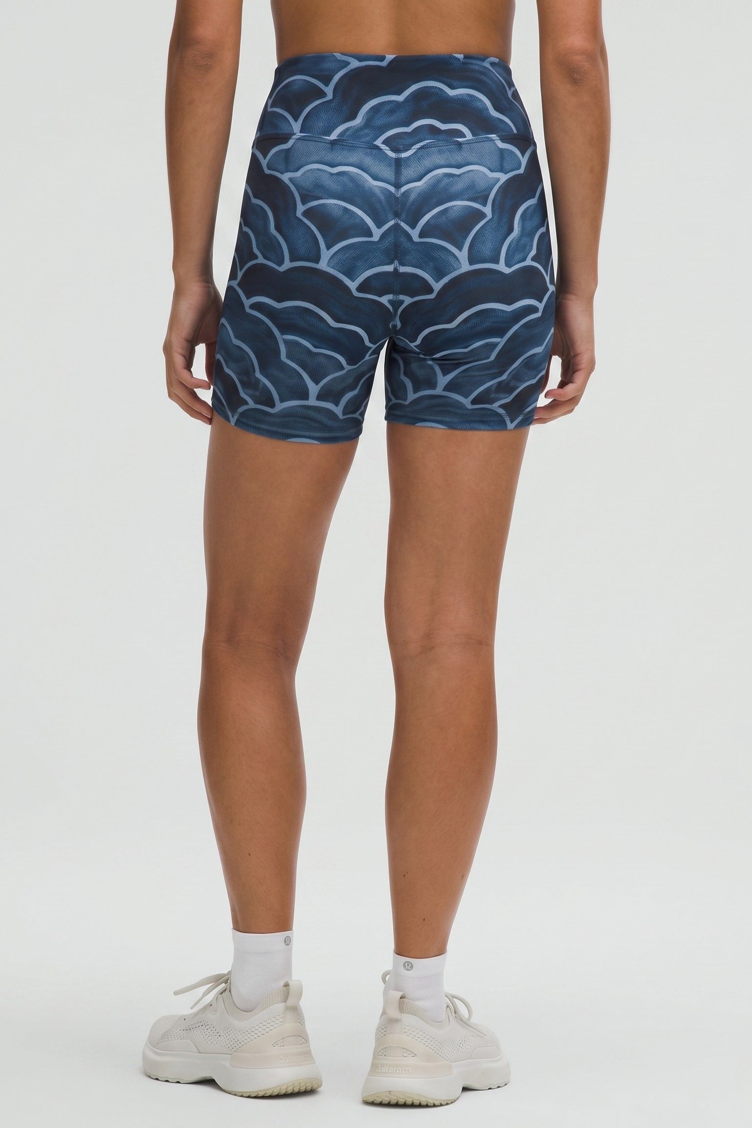 Person wearing blue patterned shorts on a white background