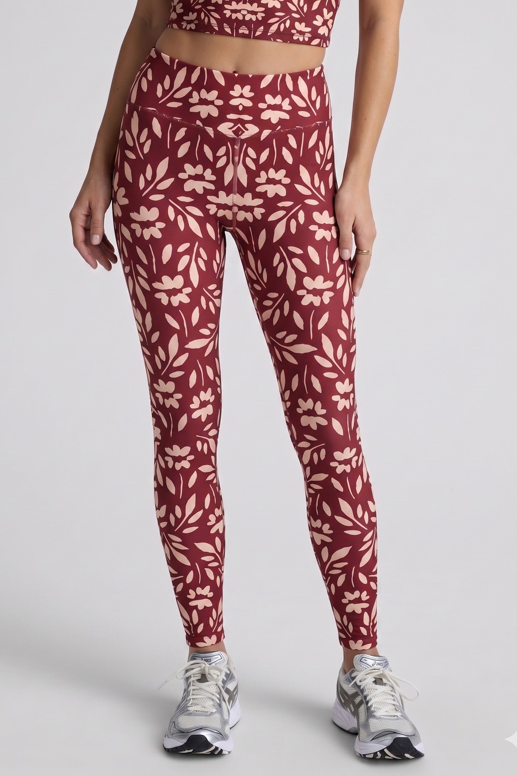 Person wearing red floral leggings on a white background