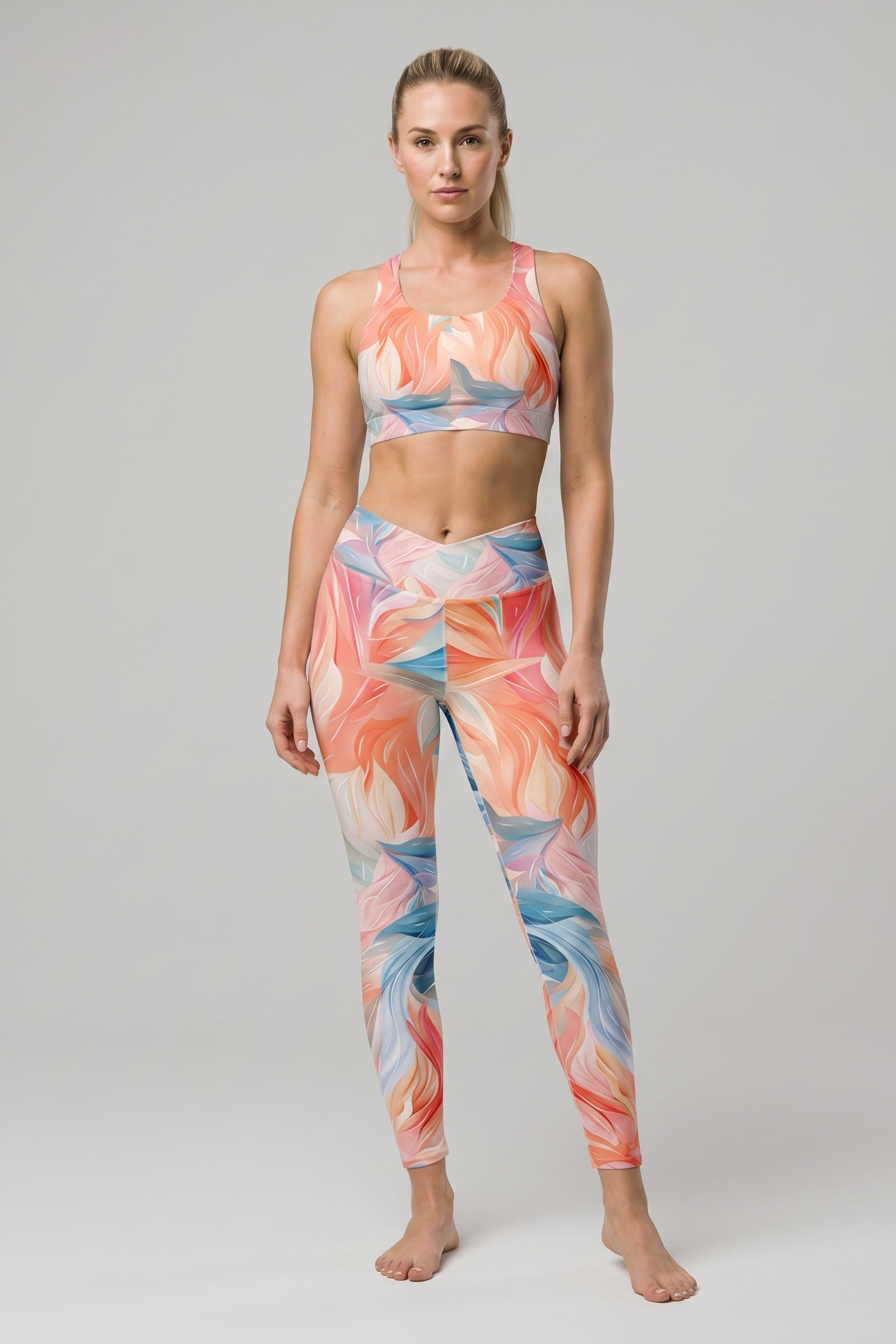 Woman wearing a colorful sports bra and leggings set on a gray background