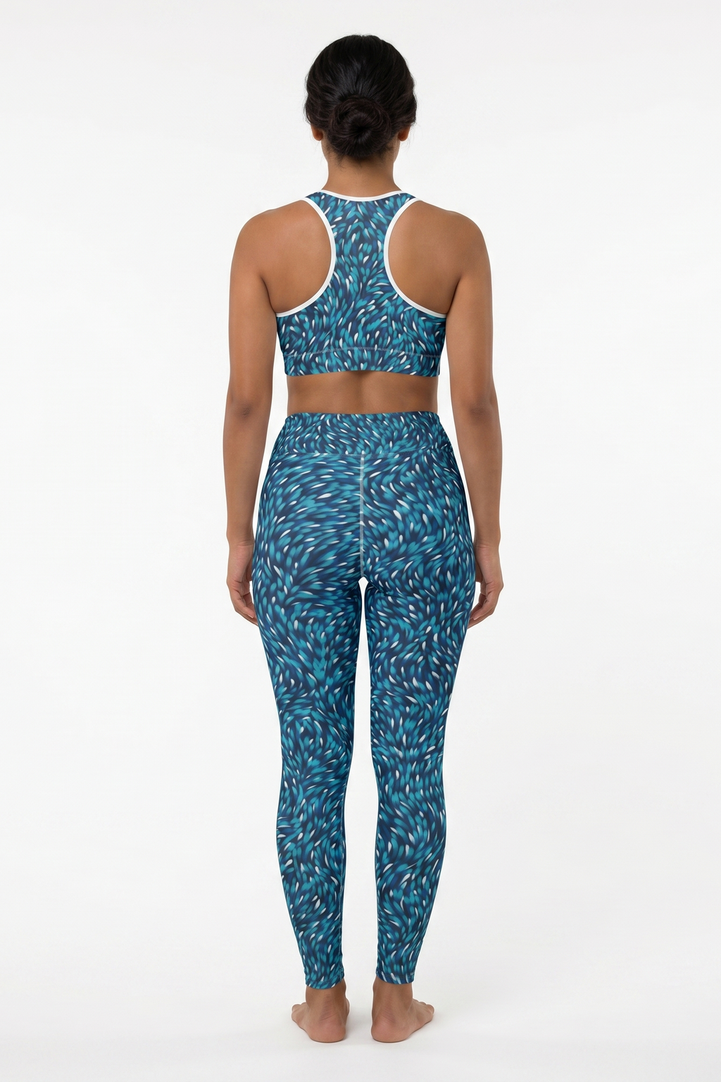 Person wearing a blue patterned sports bra and leggings set on a white background