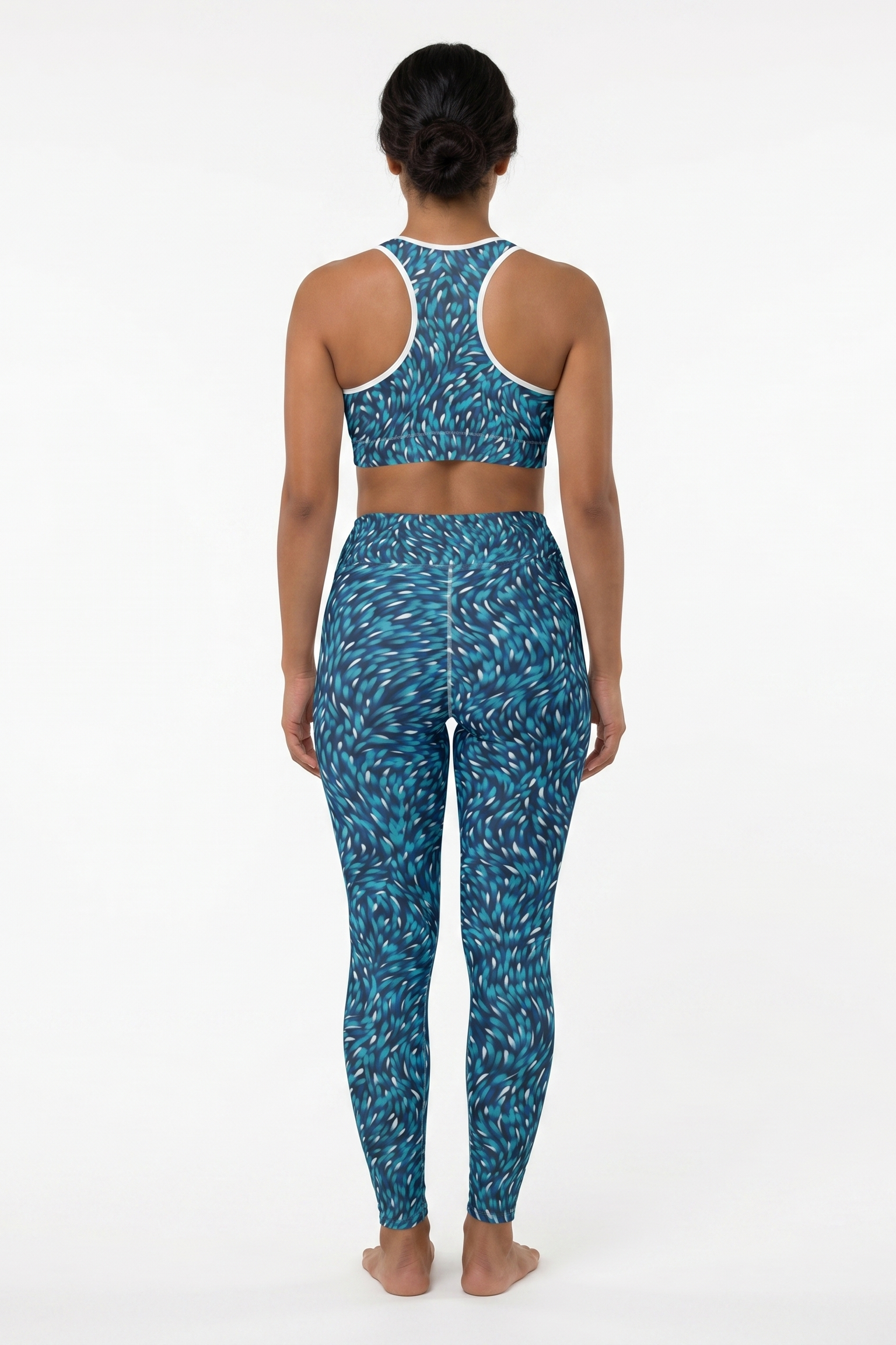 Person wearing a blue patterned sports bra and leggings set on a white background