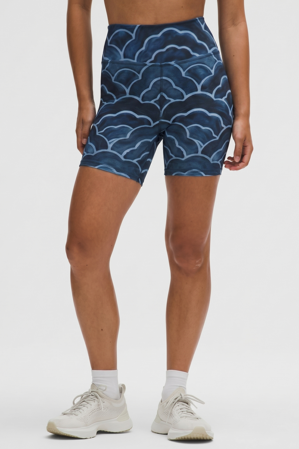 Person wearing blue patterned shorts on a white background