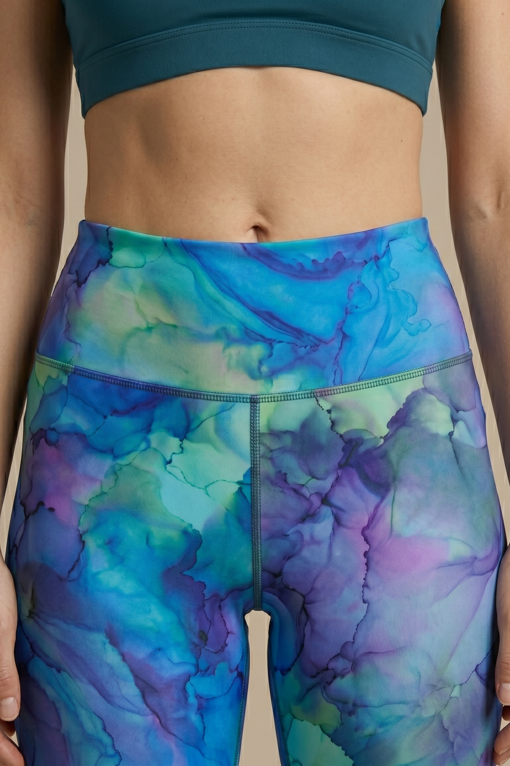 Person wearing a blue and purple tie-dye leggings with a beige background