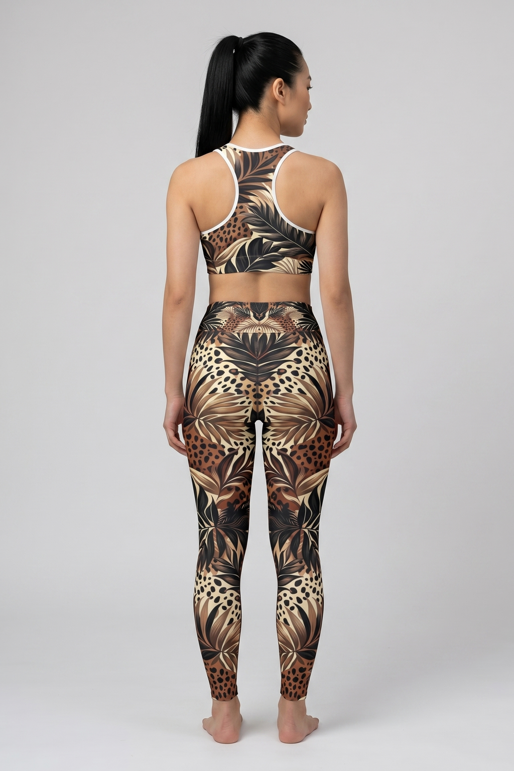 Person wearing a sports bra and leggings with a leaf pattern on a gray background